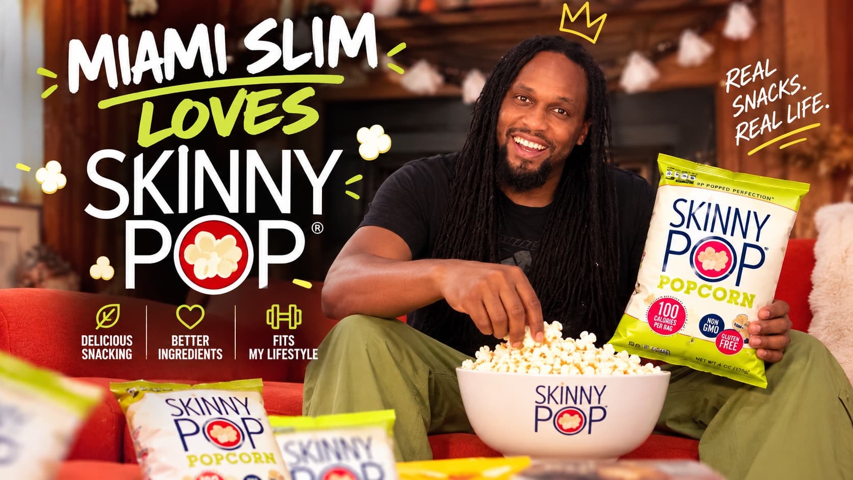 Miami Slim on a couch, grabbing popcorn and holding up a bag of SkinnyPop